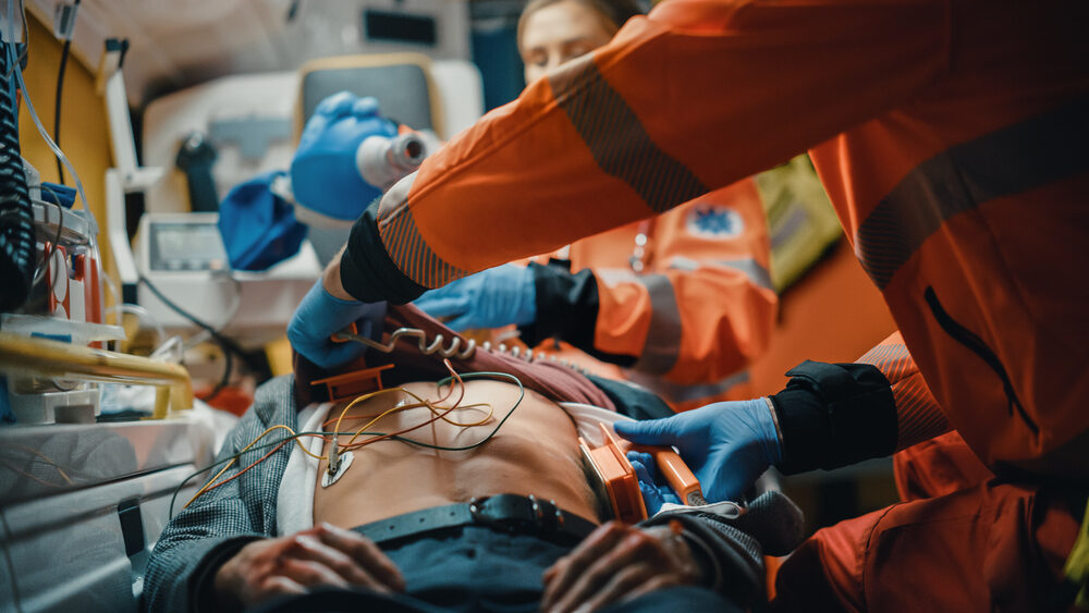 Female and Male EMS Paramedics Provide Medical Help to an Injured Patient on the Way to Hospital in ambulance