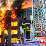 firefighters on a ladder truck at a major apartment fire