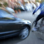 Dangerous city traffic situation with a cyclist and cars in motion blur