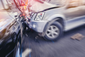 a blurred closeup view of a car crash involving a silver suv and a black suv