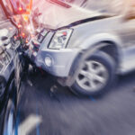 a blurred closeup view of a car crash involving a silver suv and a black suv