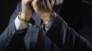 closeup of Businessman in handcuffs arrested for financial fraud