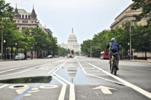 cyclist on street heading to capitol building