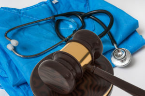 Medical scrubs with a stethoscope and gavel against a white background