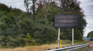 An electric sign warning motorists of a crash ahead with traffic backed up.