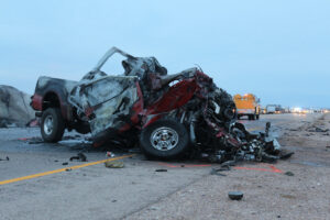 a totally destroyed red truck after a fatal accident on the highway