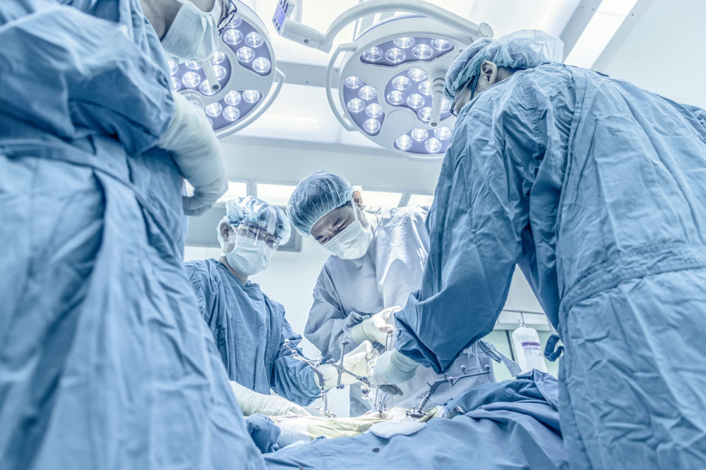 Surgeons performing total knee replacement surgery in operating room