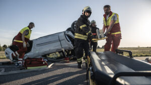 emergency responders at an overturned vehicle accident scene transporting an injured person on a stretcher