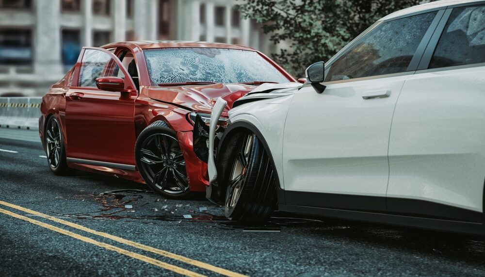 head on collision between a red sports car and a white sedan