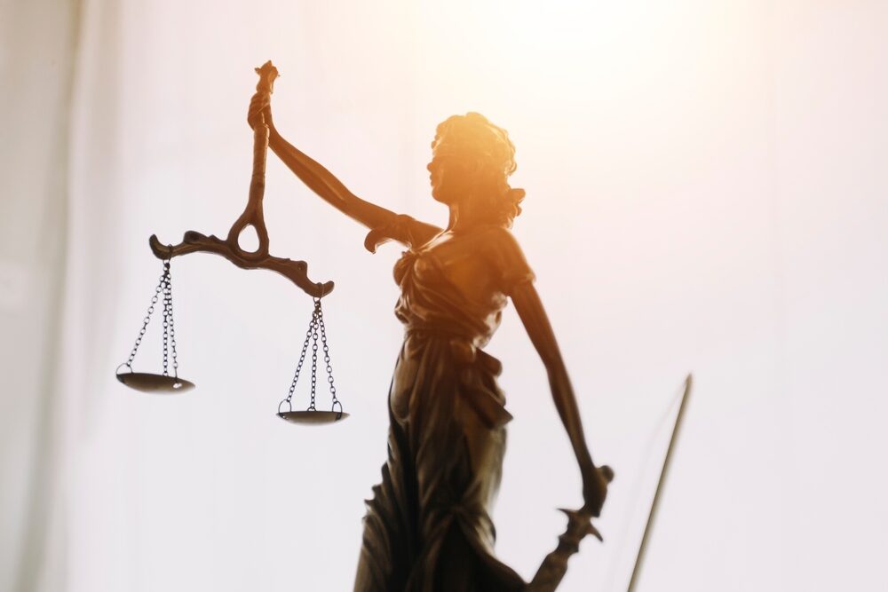 closeup of a lady justice statue with sunlight behind