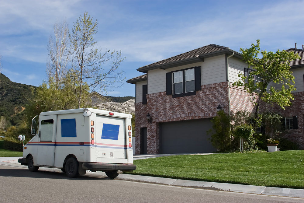 Mail truck makes a stop in a residential neighborhood.