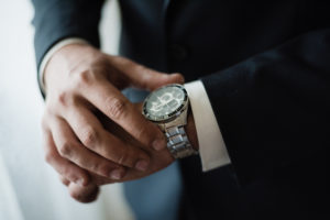 A man in a suit checking the time on his wrist watch