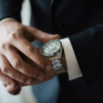 A man in a suit checking the time on his wrist watch