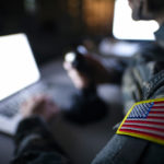 USA military intelligence working on a laptop in control center