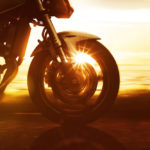 closeup of motorcycle front wheel with sunlight background