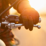 left hand of motorcyclist wearing riding glove on the clutch.