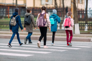 young school children walking across street at crosswalk