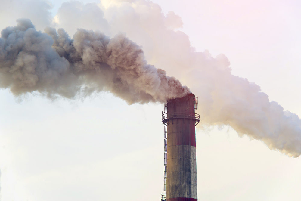 Thick smoke spews from a power plant chimney