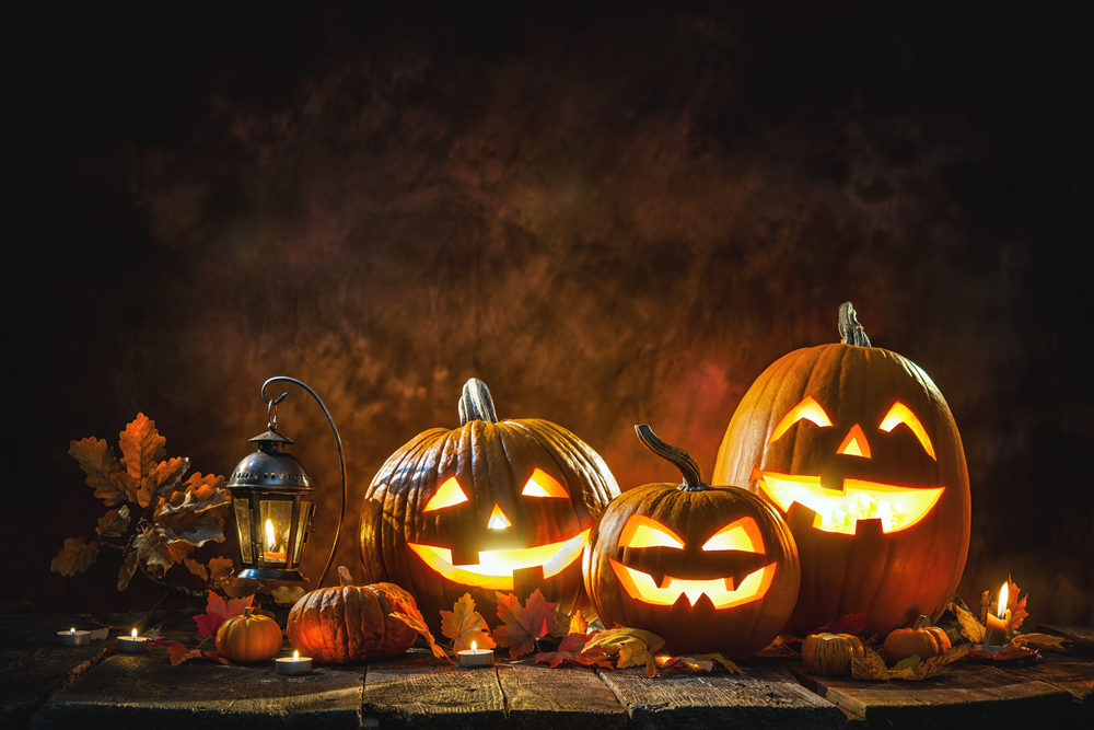 Three carved Jack-o-lanterns with burning candles