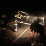 firemen spraying off the highway after a truck accident at night