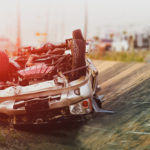 Car crash road damaged vehicle close up from careless driving tip over in roadway