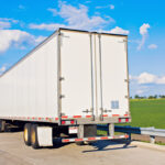 a white semi truck parked in a no parking zone on the side of the road