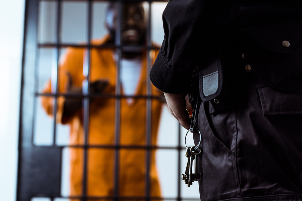 security guard standing near prison bars with keys