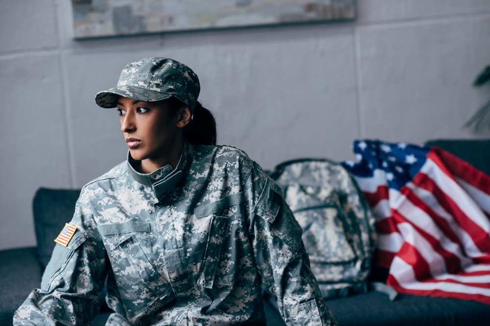 african american female soldier in military uniform with american flag on background