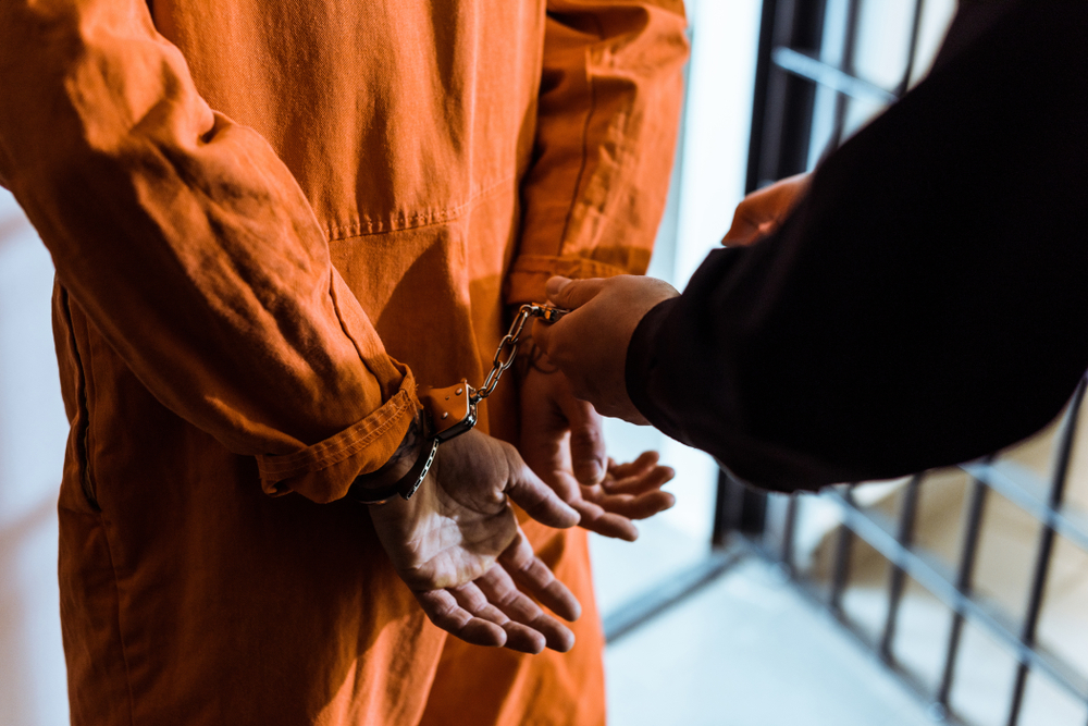 prison officer putting handcuffs on prisoner