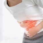 young woman holding her abdomen with painful menstrual cramps