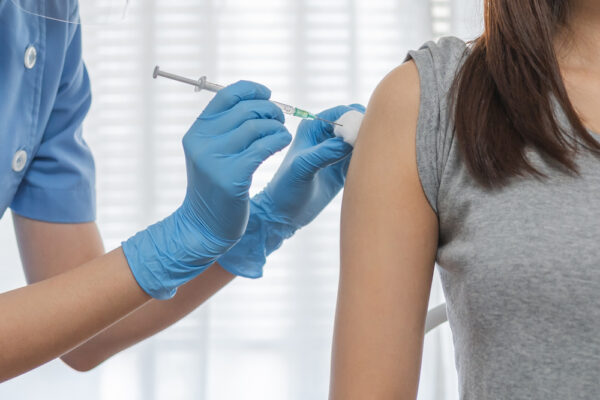 a young woman getting a depo provera birth control injection into her arm by a nurse