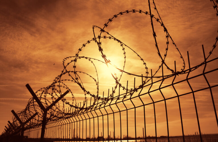 FCI Dublin prison barbed wire fence at sunset